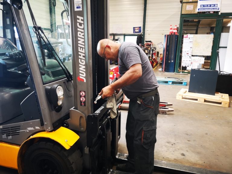 Un technicien atelier Manustra réalise le remplacement d'un flexible hydraulique sur un chariot élévateur Jungheinrich dans son atelier de réparation